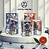 Assorted Crystal Twin 50K vape devices displayed on a white round platform, surrounded by blueberries and half a grapefruit, with branded packaging in the background.